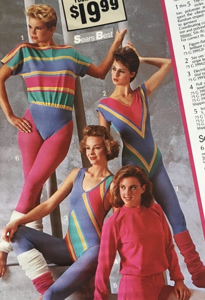 Quatro modelos em uma propaganda de revista em 1980. Três delas estão usando collant nas cores azul, rosa, verde e amarelo. A quarta modelo usa um conjuntinho rosa.