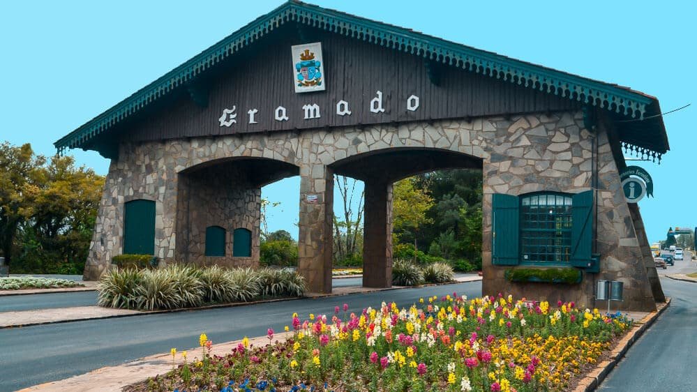 Entrada da cidade de Gramado com algumas plantas e flores coloridas. 