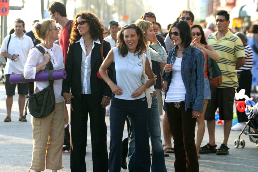 Grupo de mulheres rindo em meio a uma multidão